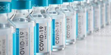 Row Covid-19 or Coronavirus vaccine flasks on white background