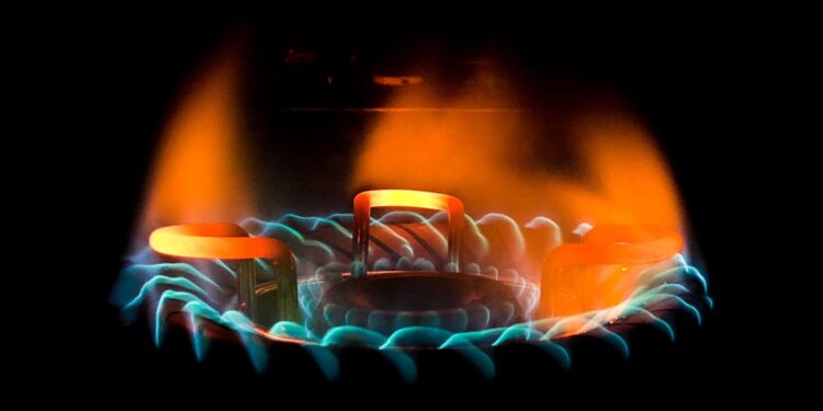 A closeup shot of a beautiful blue-green flame in a gas stove